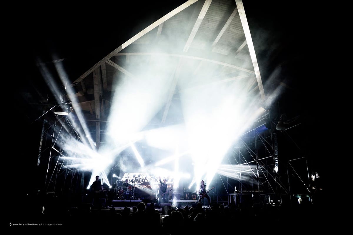 Need of Green in concerto su un grande palco illuminato davanti al pubblico